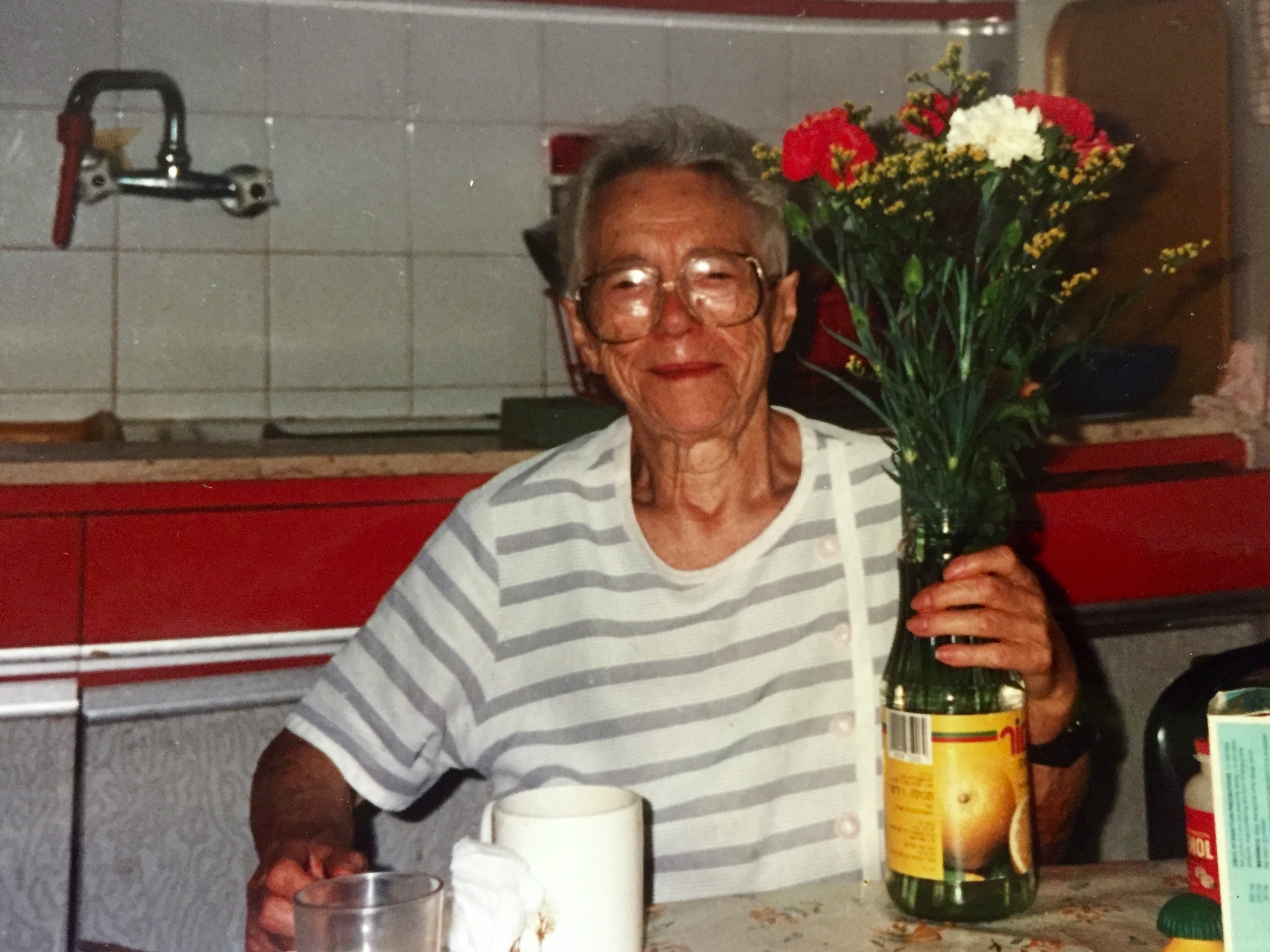 Sadie Kasachkoff later in life, holding flowers at home.