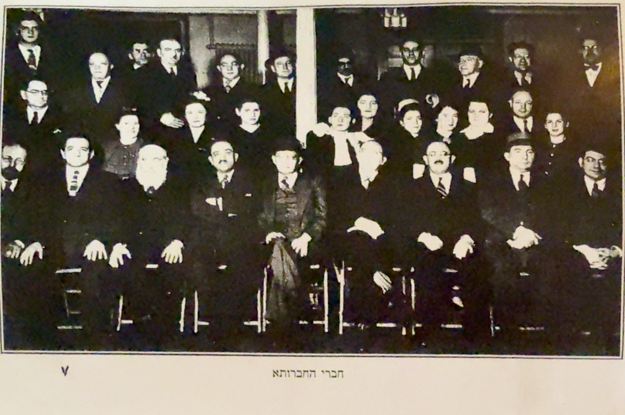 Historical group photograph with its original Hebrew caption visible; Dov Bear Kasachkoff is believed by the family to be seated in the front row, second from the right.